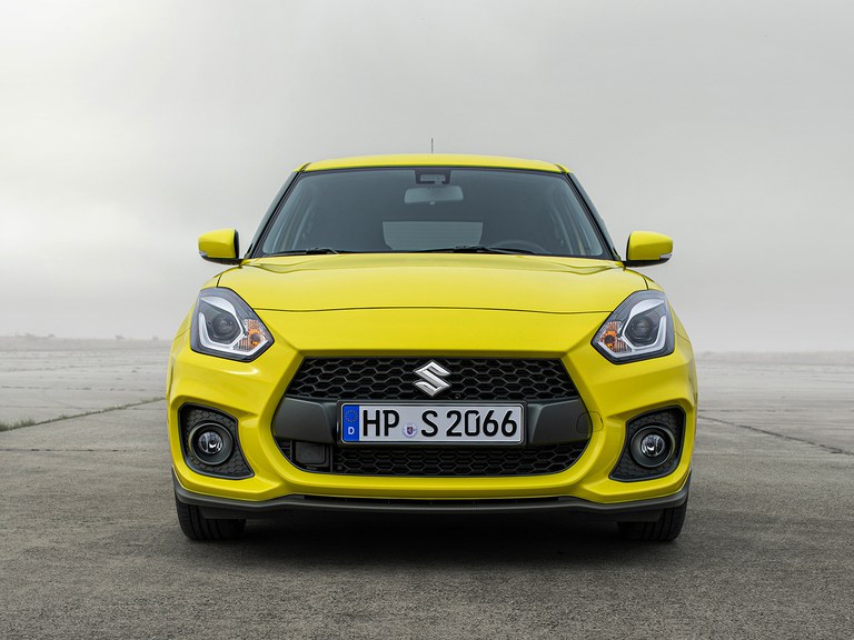 Von vorne fotografierter Suzuki Swift Sport Hybrid in Champion Yellow, Fokus auf der Frontpartie.