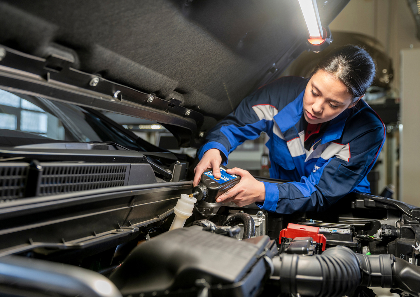 ECSTAR-Extra-Suzuki.jpg Eine Suzuki Mechanikerin füllt Öl nach
