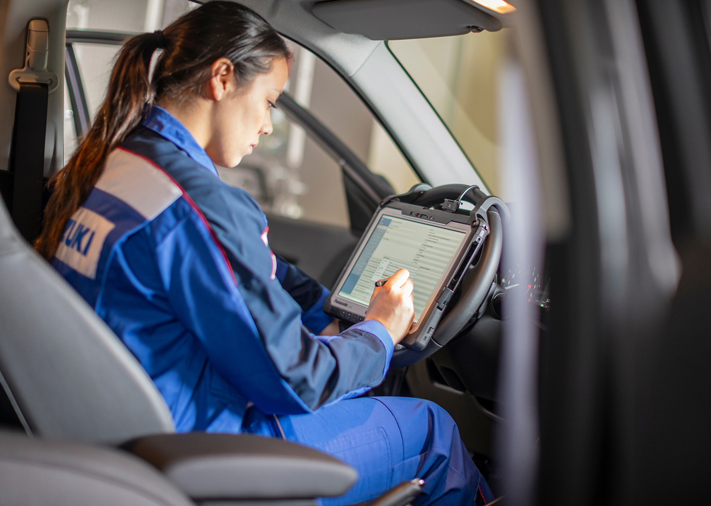 Suzuki-Service.jpg Eine KFZ-Mechanikerin prüft eine Checkliste